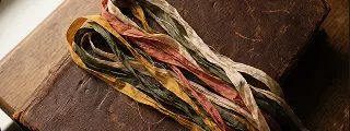 A silk bookmark ribbon laid across an old leather binding